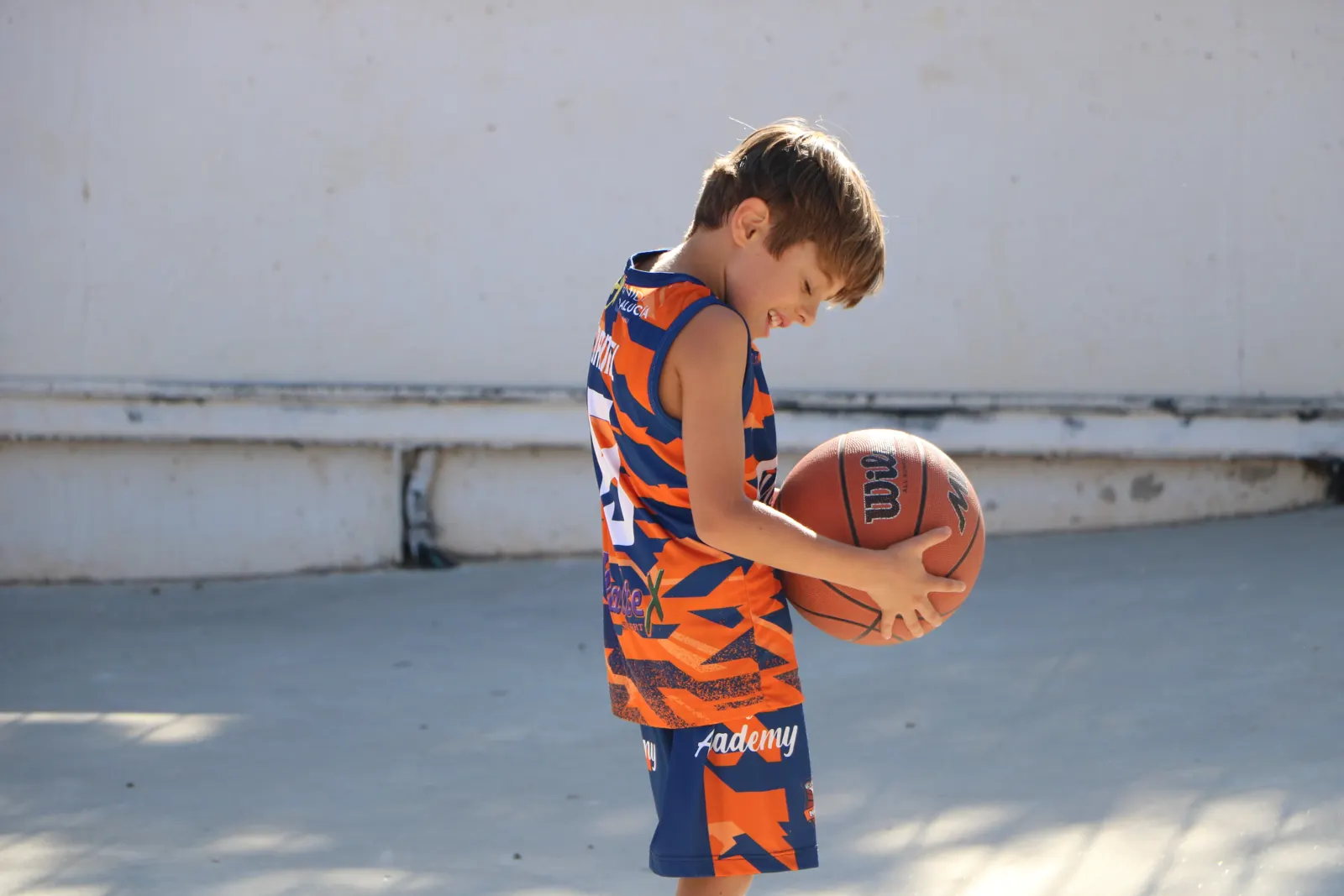 Niño con el balón en la pista